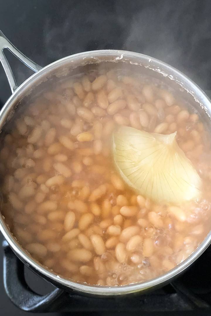 Pot of freshly cooked beans on black stove.